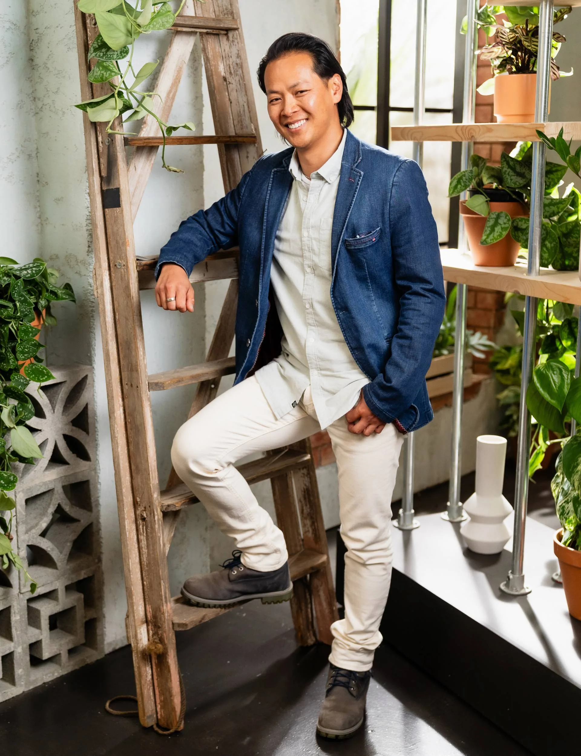 Bayley LuuTomes leaning on a ladder surrounded by plants