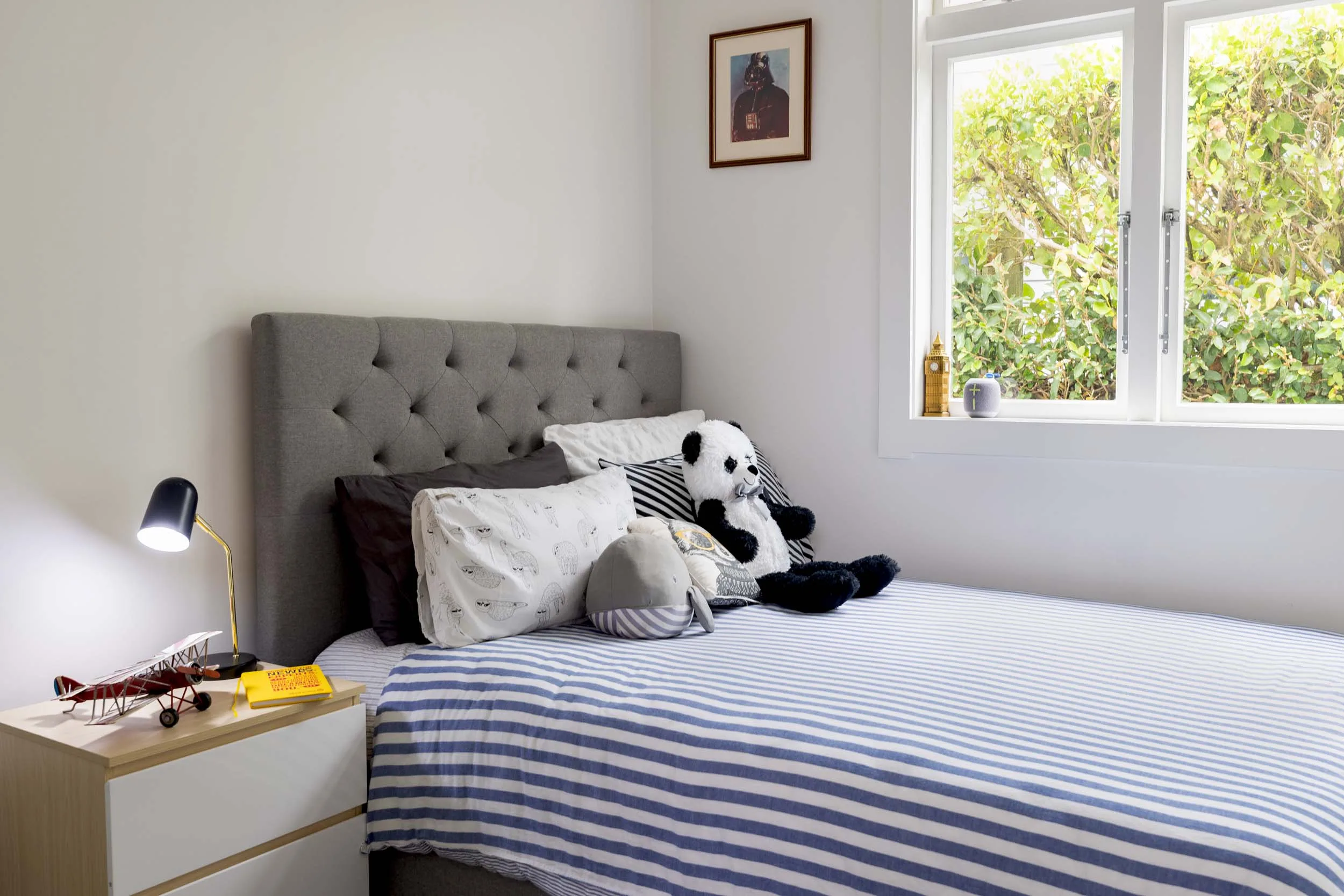 A kids bedroom with navy and white striped bedding