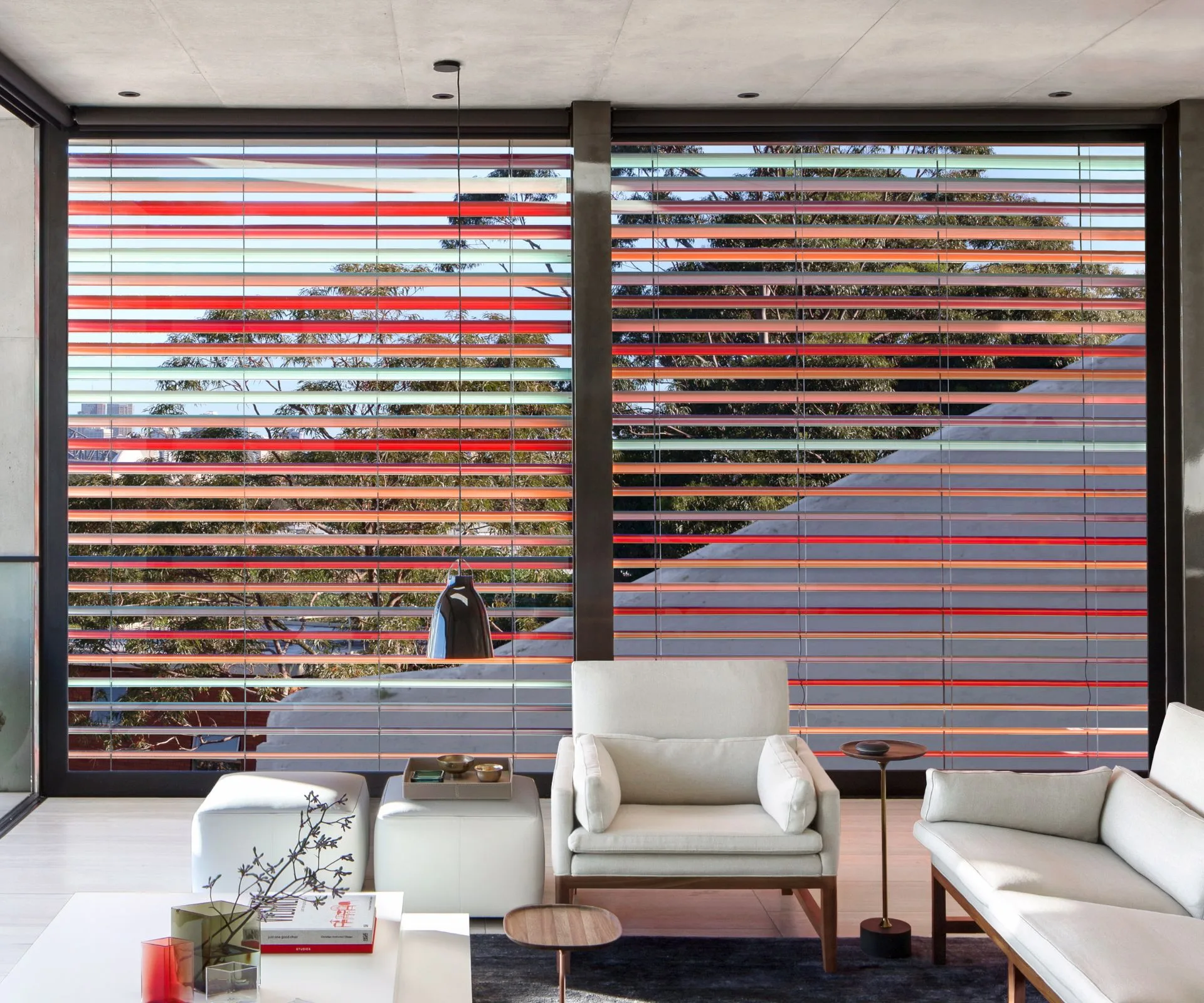 Rainbow coloured blinds behind a white leather armchair