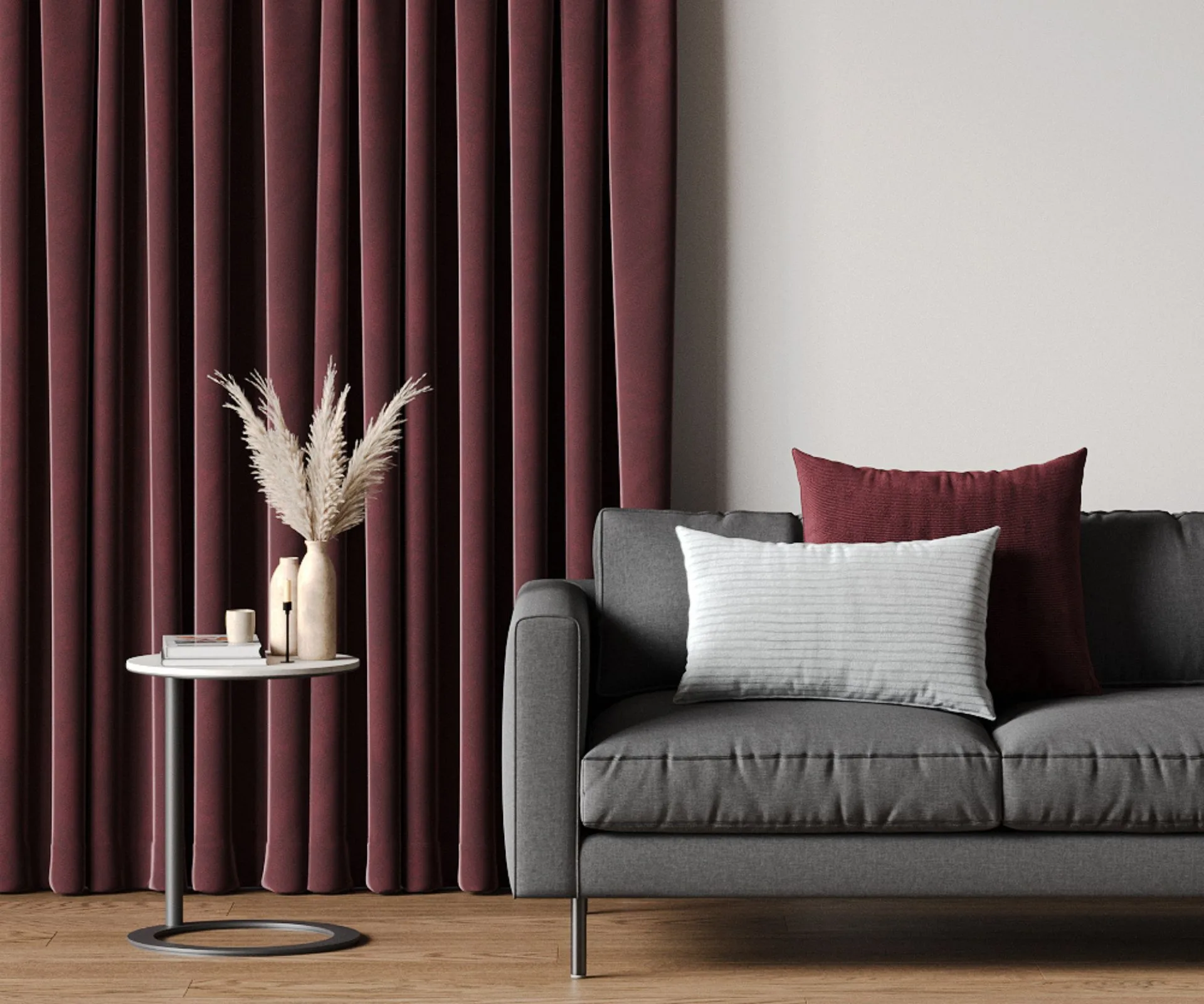 A floor-length maroon curtain hanging beside a dark grey couch