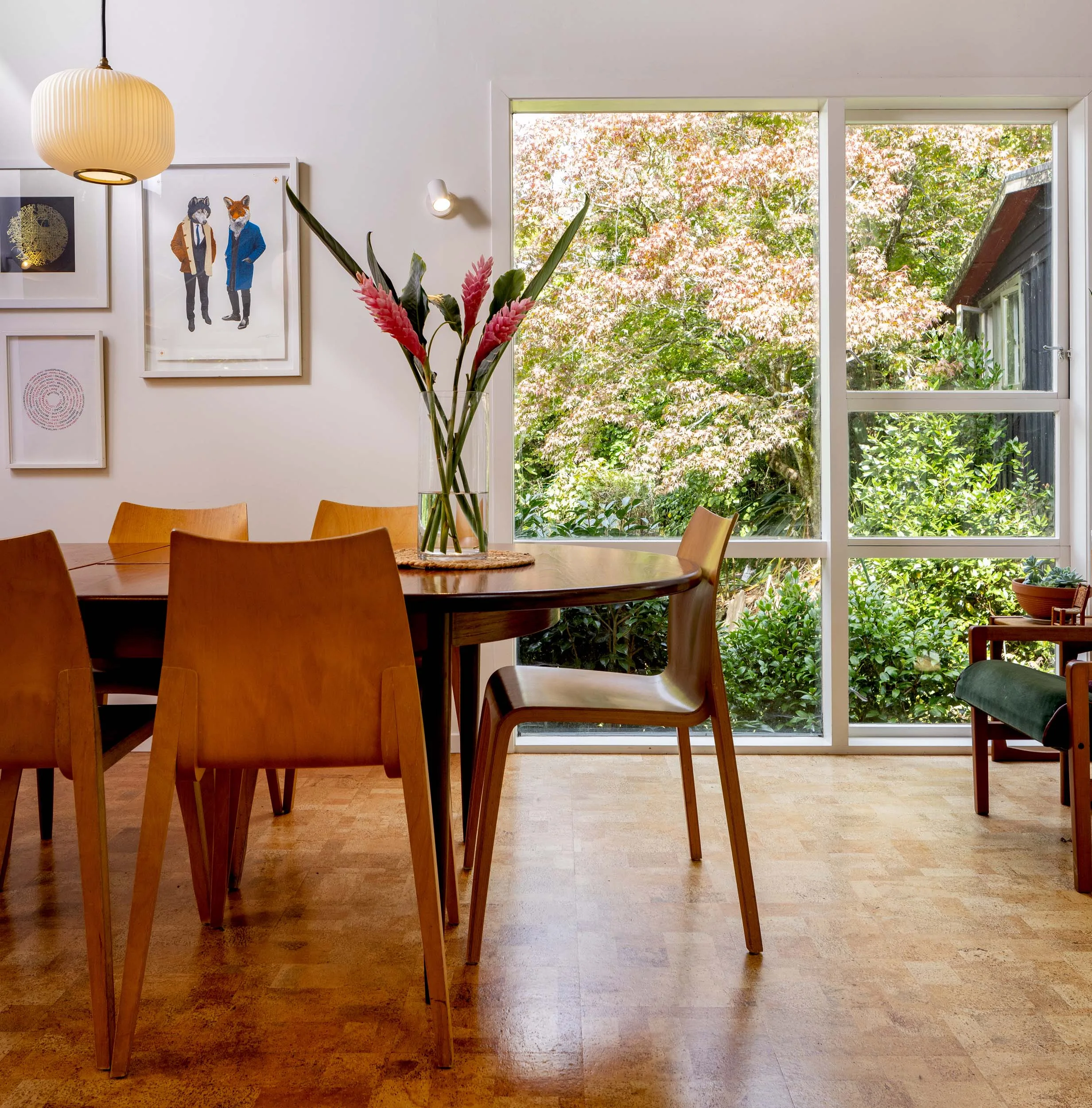 Dining room table with wooden chairs around it and a vase in the middle