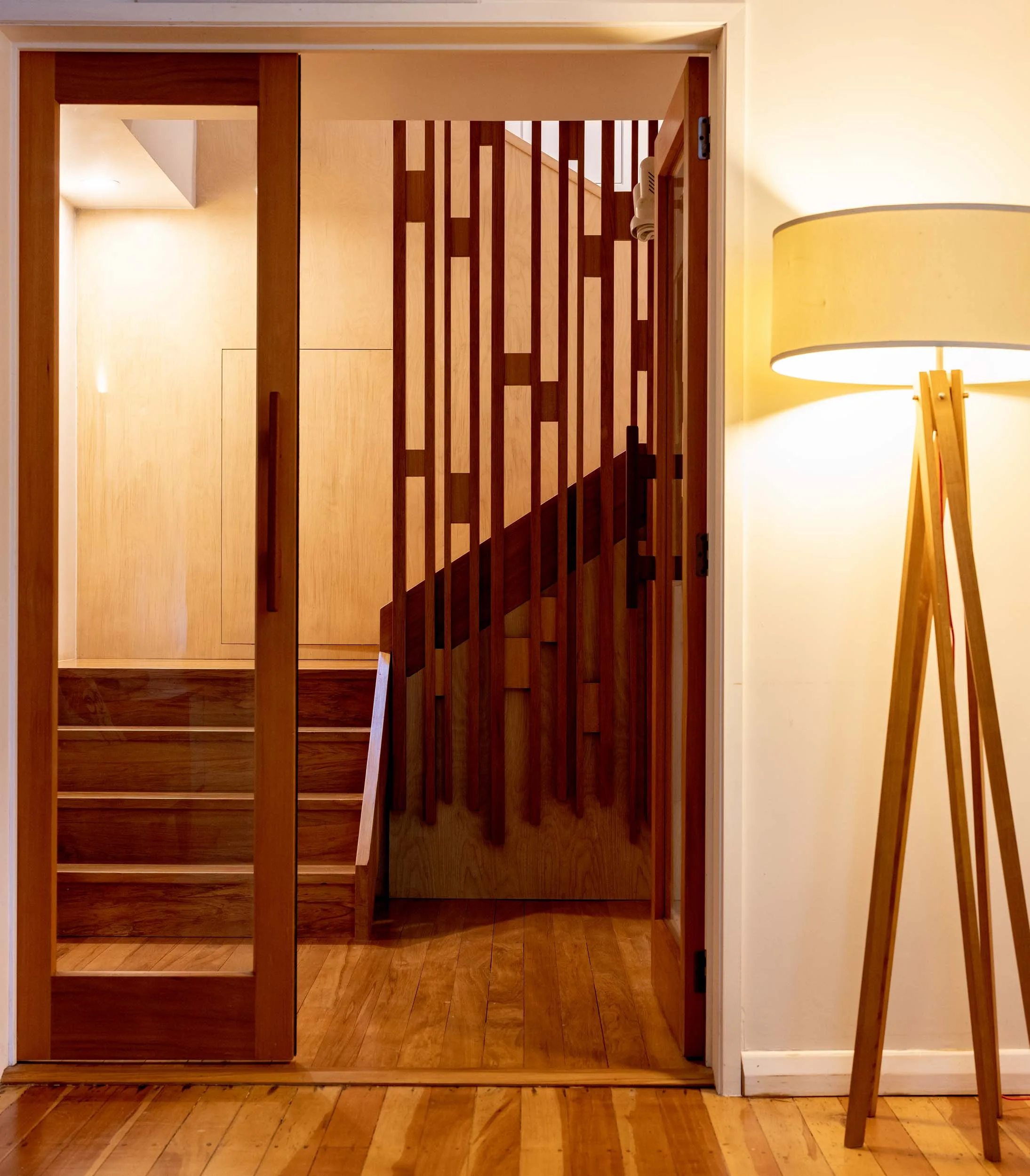 The stairwell with a round lamp and glass door on the other side of the hallway