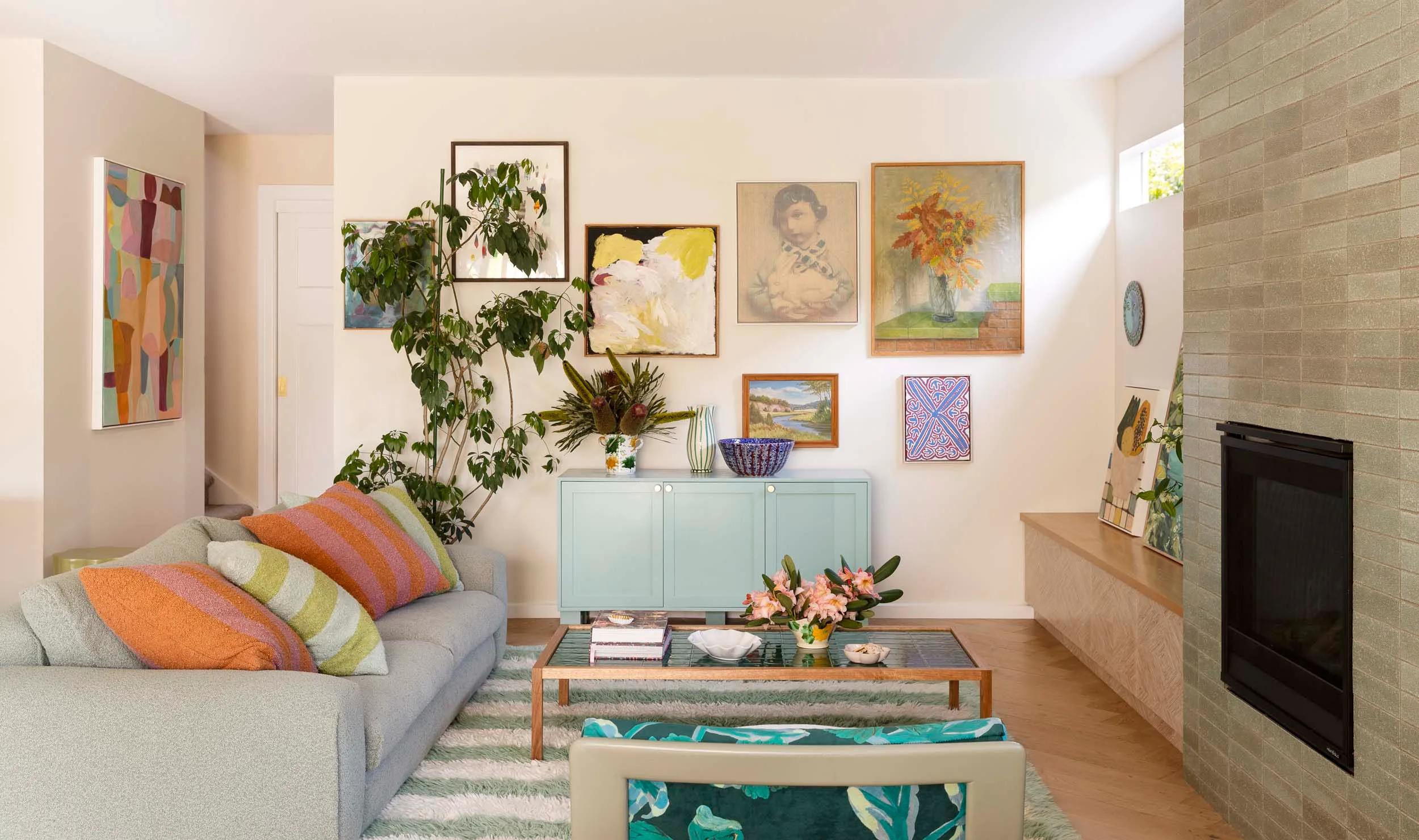 The living room with a tiled modern fireplace and grey and green furniture