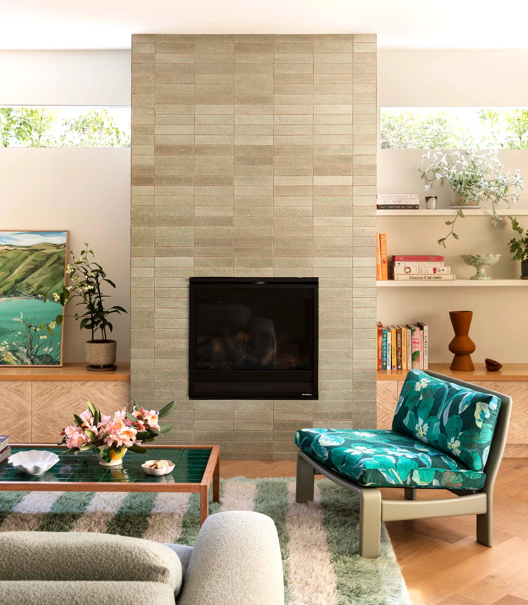 The living room with a tiled modern fireplace and grey and green furniture
