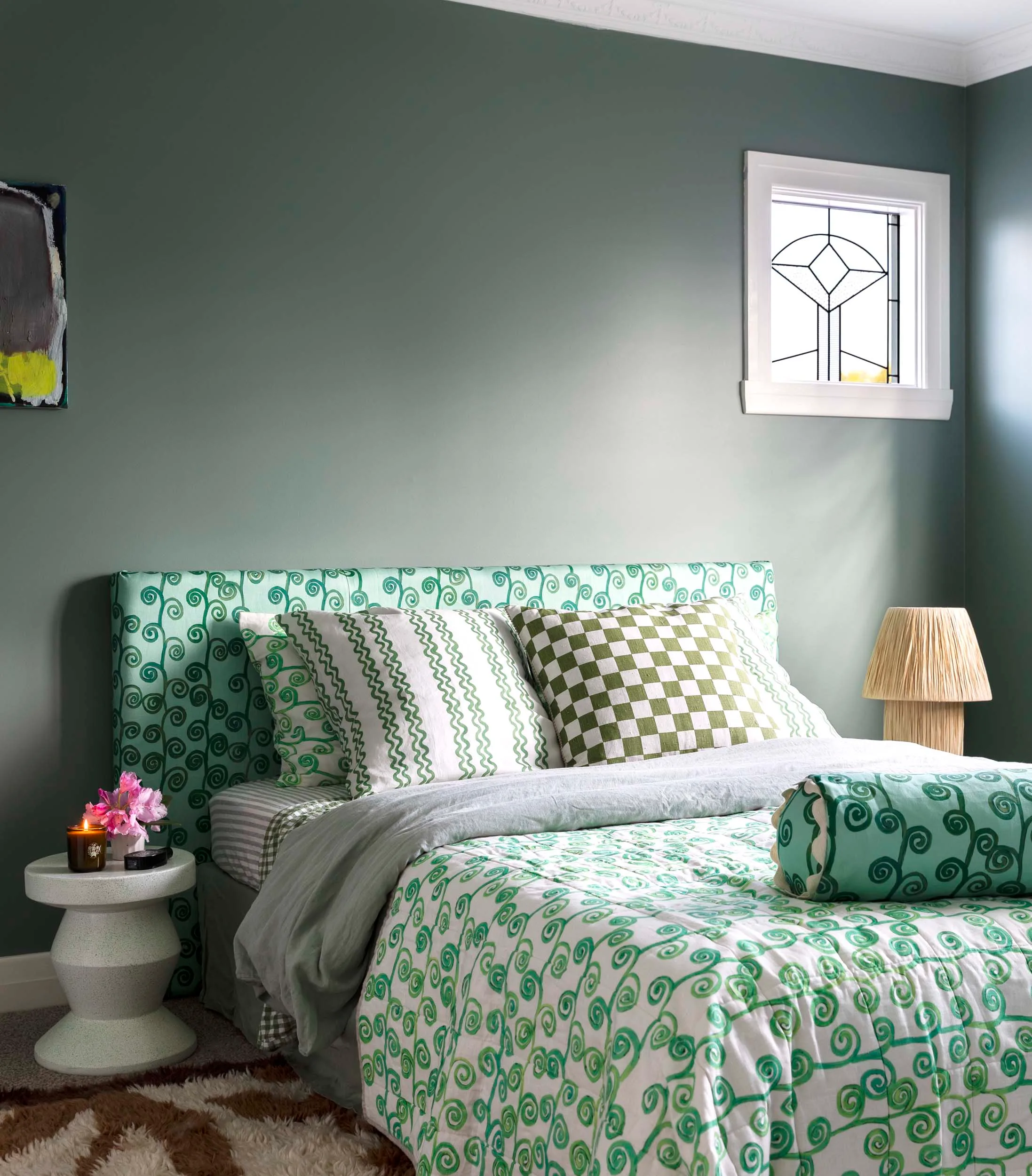 A green themed bedroom with dark green walls and lime green bedding