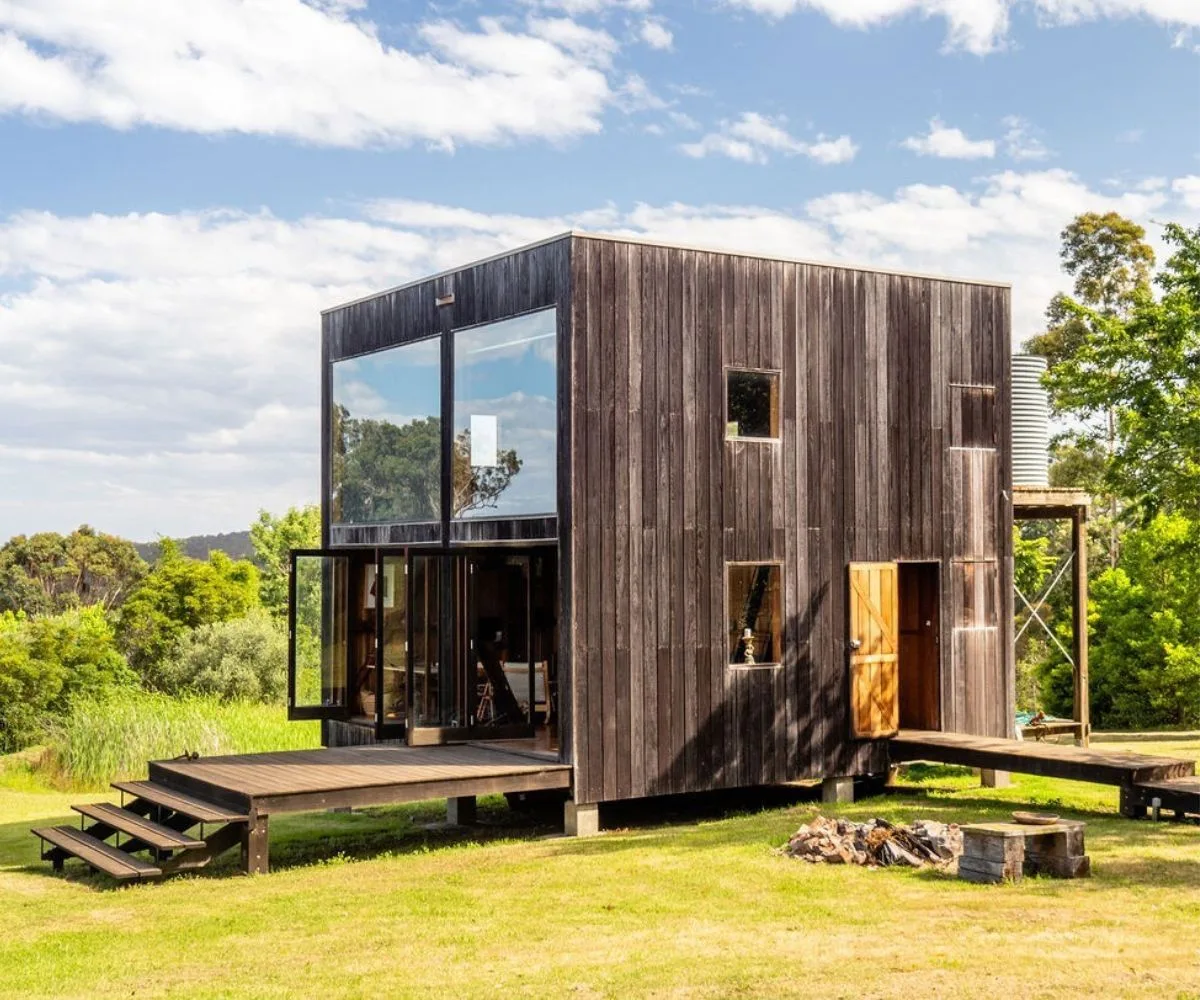 boxhouse airbnb wooden cube shaped building surrounding by lush greenery