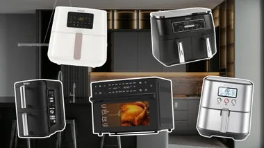 A collection of etched air fryers placed in front of a dark, luxe kitchen