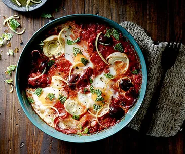 Baked eggs with artichoke, salami, tomato, olives and mint