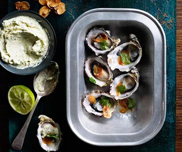 Grilled oysters with lemongrass crème fraîche, fried garlic and lime