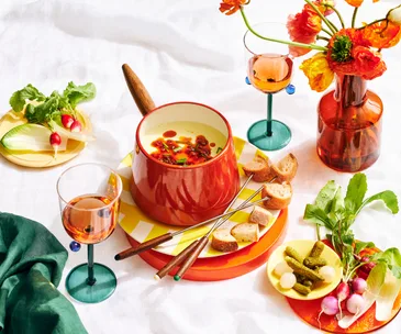 cheese-fondue-set-and-wine-glasses-on-table