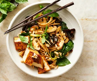 Udon noodles recipe stir fried with mustard greens, mushroom, tofu and peanut sauce