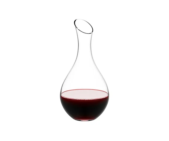 Clear glass wine decanter with a modern curved design, partially filled with red wine against a white background.