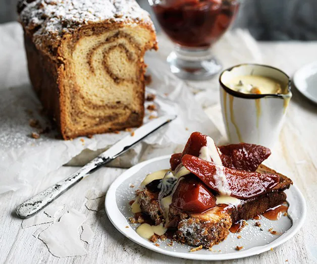 Swirled bread loaf beside a plate of French toast topped with poached pears and cream, with a knife and bowl of sauce.