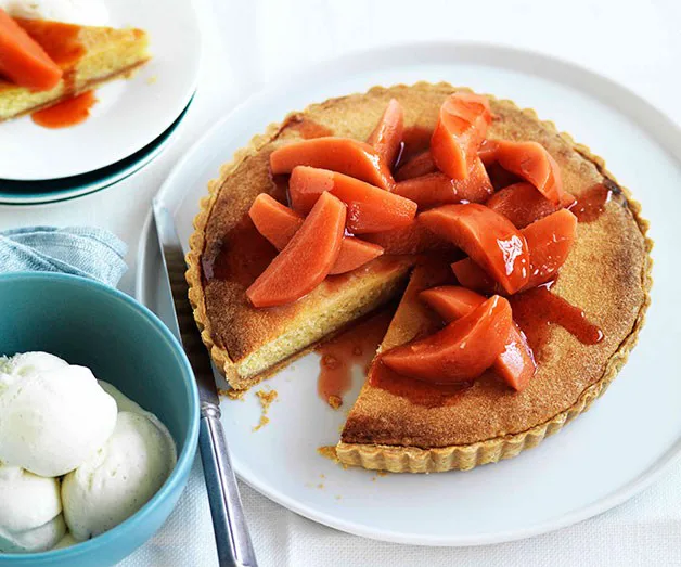 Quince tart on a white plate with a slice missing, served with a bowl of ice cream.