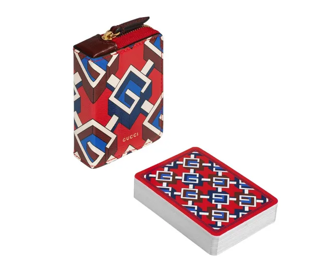Red and blue geometric patterned Gucci card case and deck of cards.
