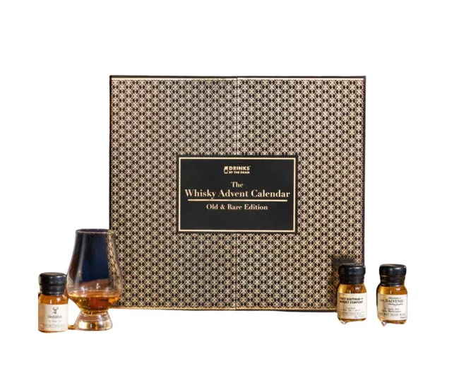 Whisky Advent Calendar with a patterned box, two small bottles, and a glass containing whiskey.