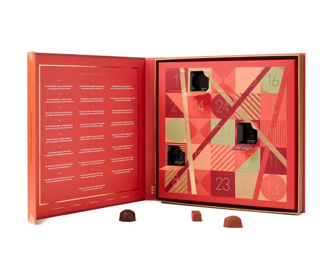 Luxury advent calendar with open compartments and chocolates on a white background.
