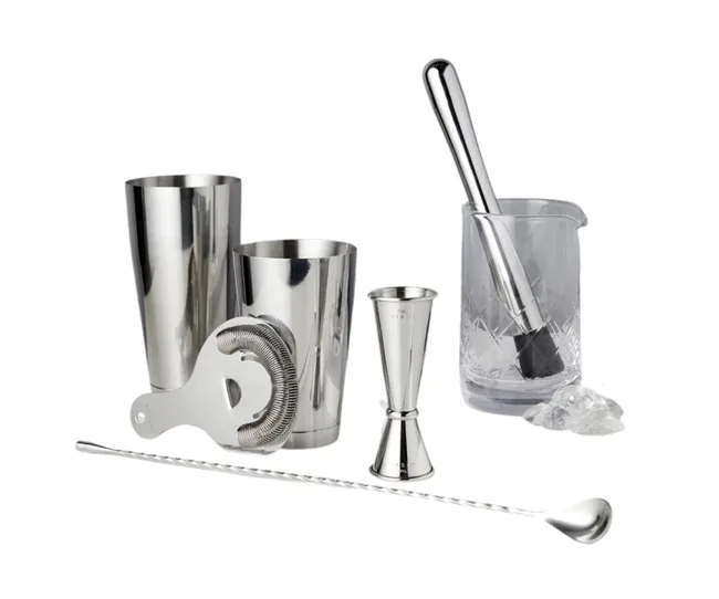 Cocktail set with shaker, strainer, jigger, bar spoon, muddler, and mixing glass on white background.
