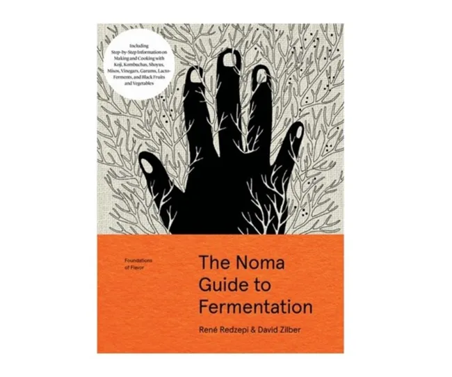Book cover: "The Noma Guide to Fermentation" by René Redzepi and David Zilber, black hand design, orange background.