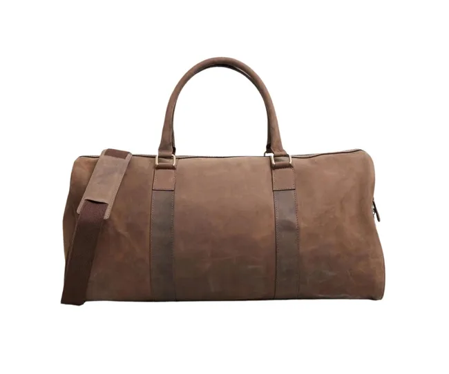 Brown leather duffel bag with dual handles and an adjustable shoulder strap, set against a white background.