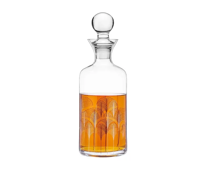 A decorative glass decanter filled with amber liquid, featuring an etched geometric pattern and a spherical stopper.