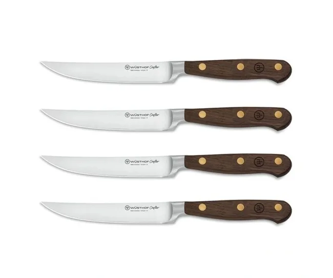 Four Wüsthof Crafter steak knives with wooden handles and silver blades arranged horizontally.