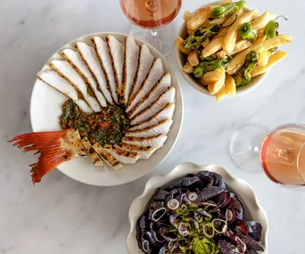 Petermen in St Leonards, Sydney from Josh and Julie Niland. Photo of a fish dish, a mussels dish, and chips on white marble table