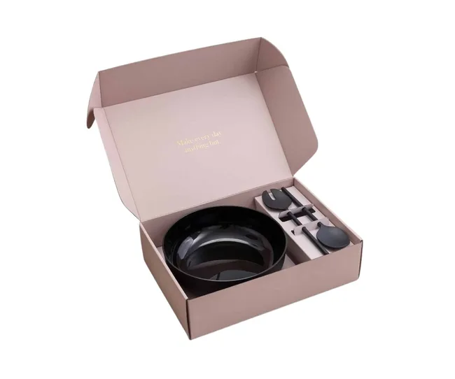 Open box with black bowl and utensils inside. Lid says "Make every day anything but."