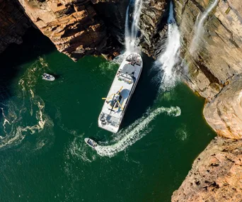 The Kimberley cruises ship True North in the Kimberley WA. Photo of the Kimberley cruise ship at the base of a waterfall