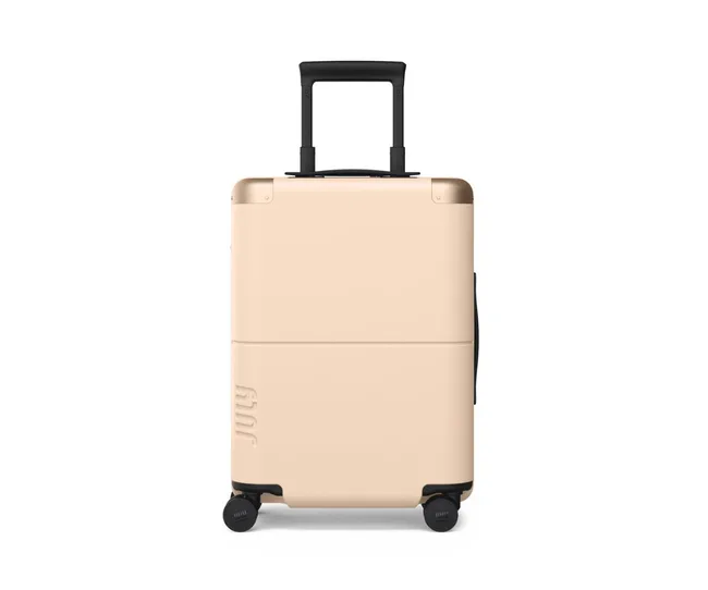 Beige hard-shell suitcase on wheels, standing upright with a black retractable handle.