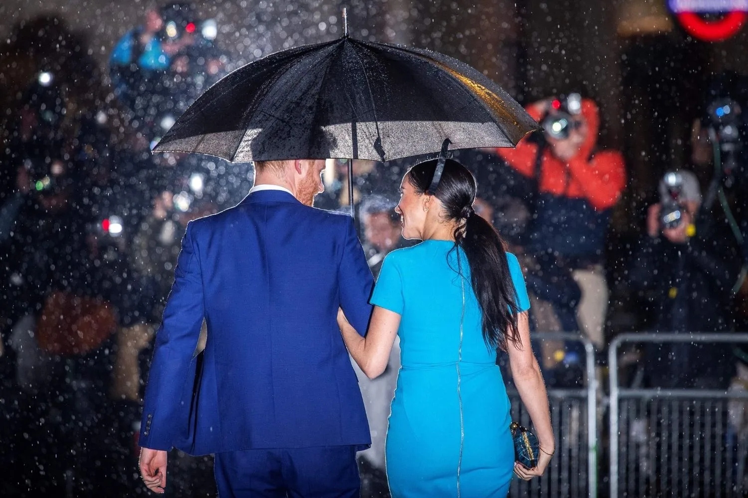 Meghan and Harry sharing an umbrella.