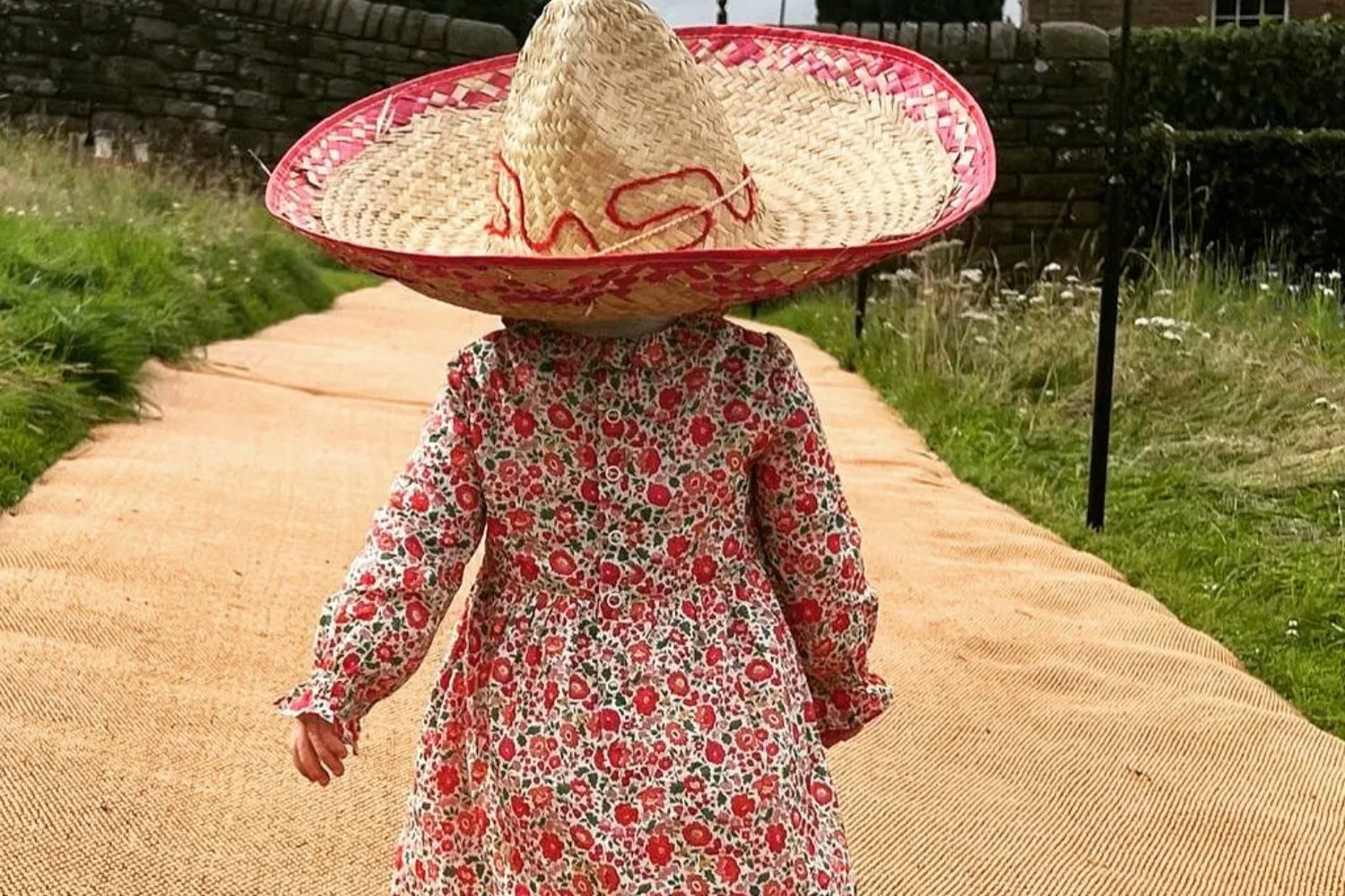 princess beatrice's daughter sienna walks bare foot in a red floral dress and a large wide brim hat