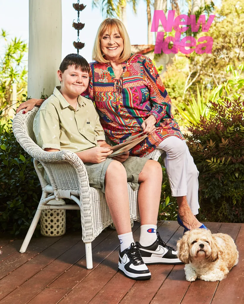 A woman, Denise Drysdale, poses with her grandchild and dog.
