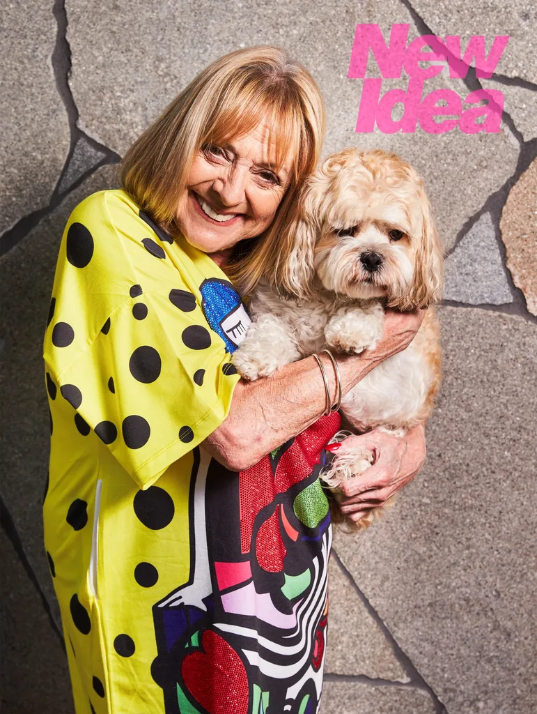 A woman, Denise Drysdale, poses with her dog at home.