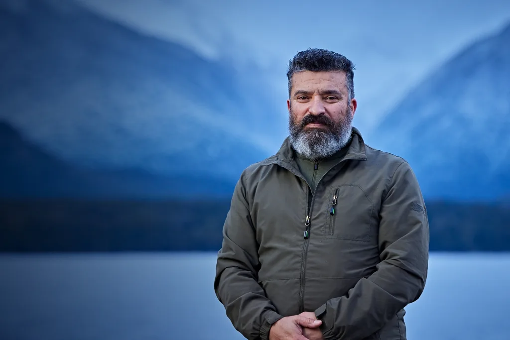 Alone contestant Jack wearing a dark grey coat standing outdoors in a cold environment.