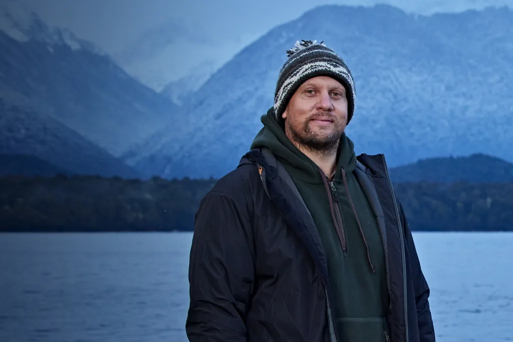 Alone contestant Jason standing outdoors in a dark blue coat in a cold environment.