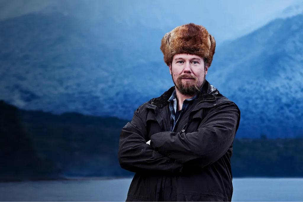 Alone contestant Krzysztof standing outdoors in a dark coat in a cold environment.