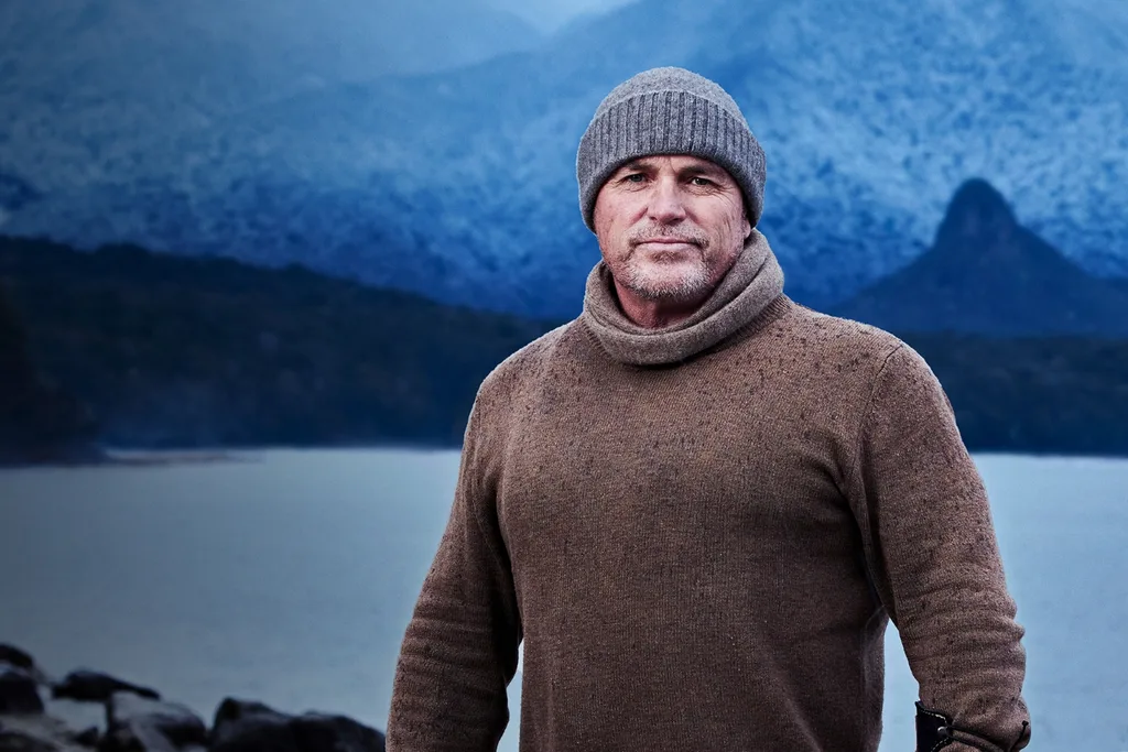 Alone contestant Mike standing outdoors in a dark brown jumper in a cold environment.