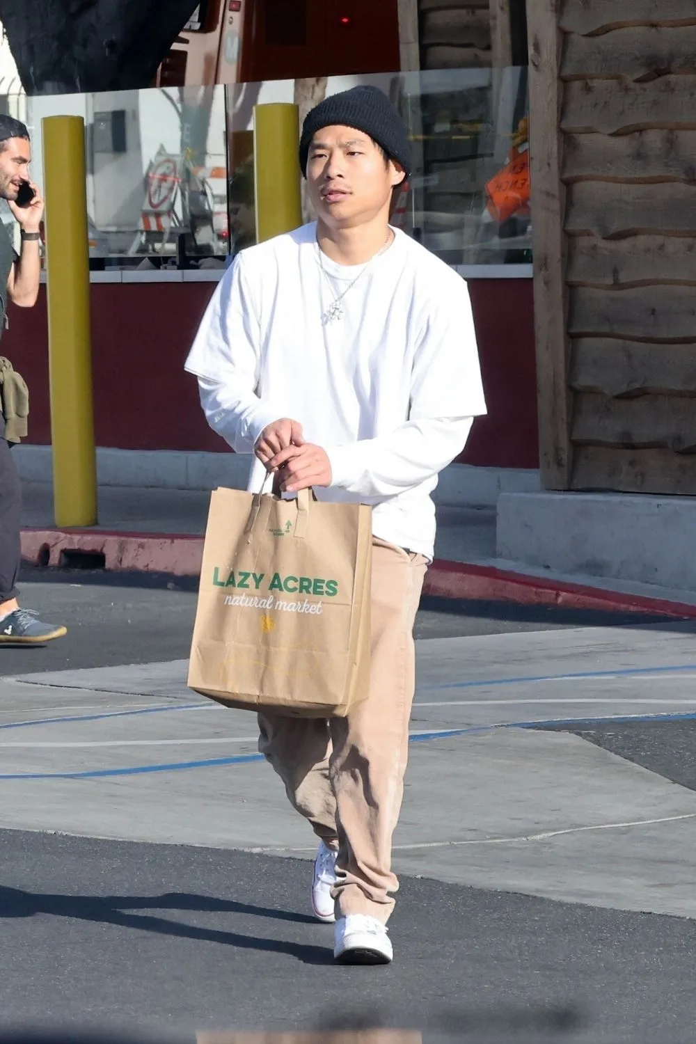 Pax papped picking up groceries in April 2024 wearing a black beanie, white long sleeve and brown pants