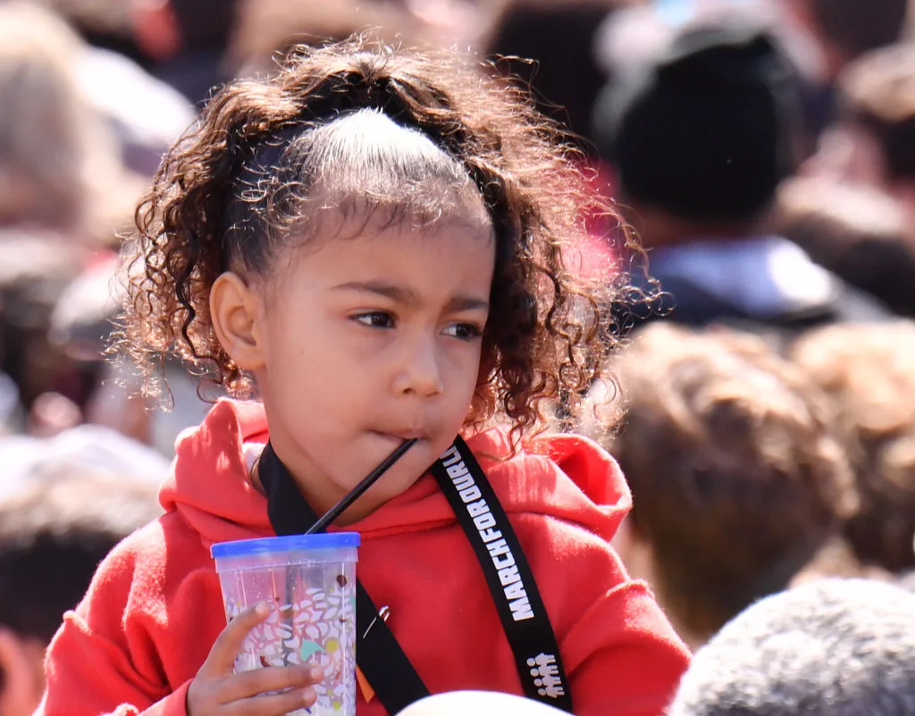 North West wearing a red jumper