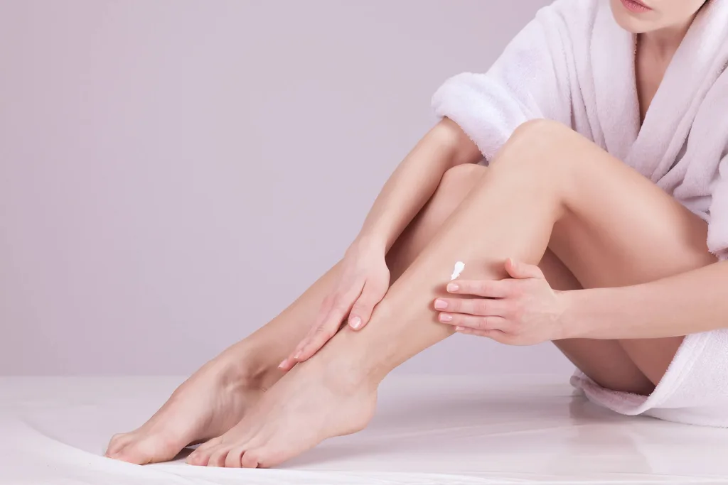 Woman applying permanent hair removal cream to her legs