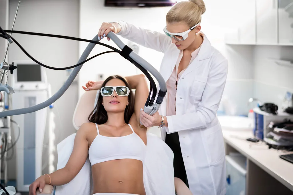 Woman in protective glasses getting laser hair removal by doctor in white lab coat