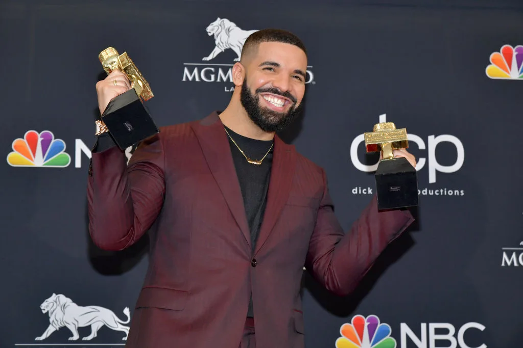 Drake poses with trophies at an awards night