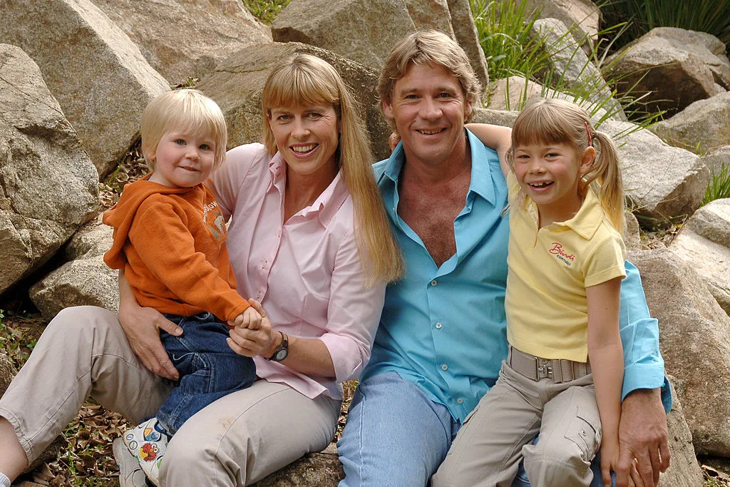 Steve Irwin and his family sitting in front of some rocks