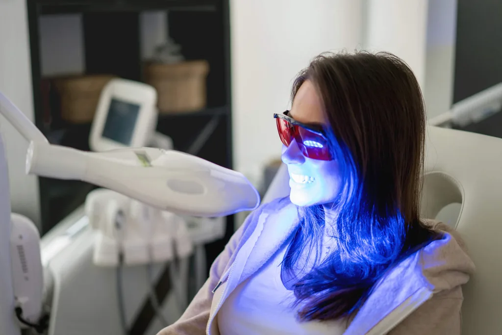 A woman getting laser teeth whitening in a dentist
