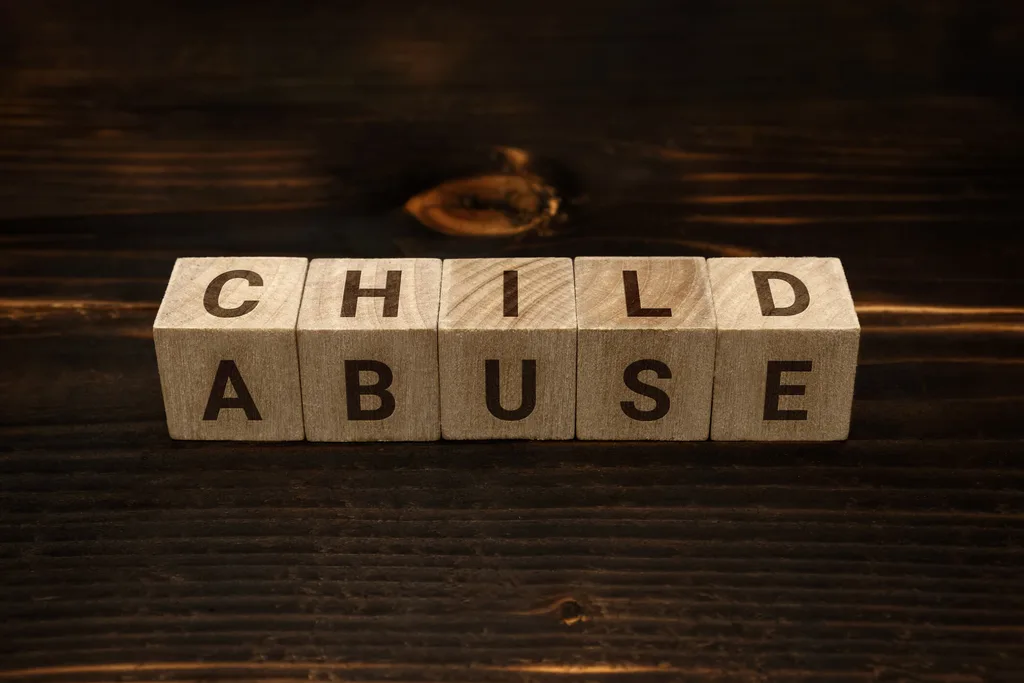 Wooden blocks spelling 'Child Abuse' on a wooden table