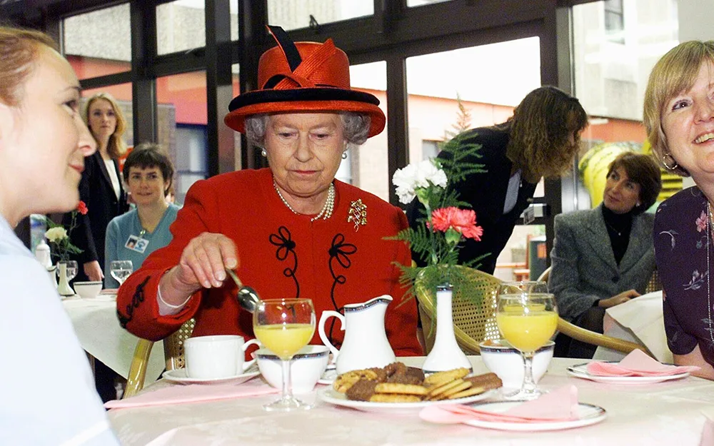 Queen Elizabeth II eating tea