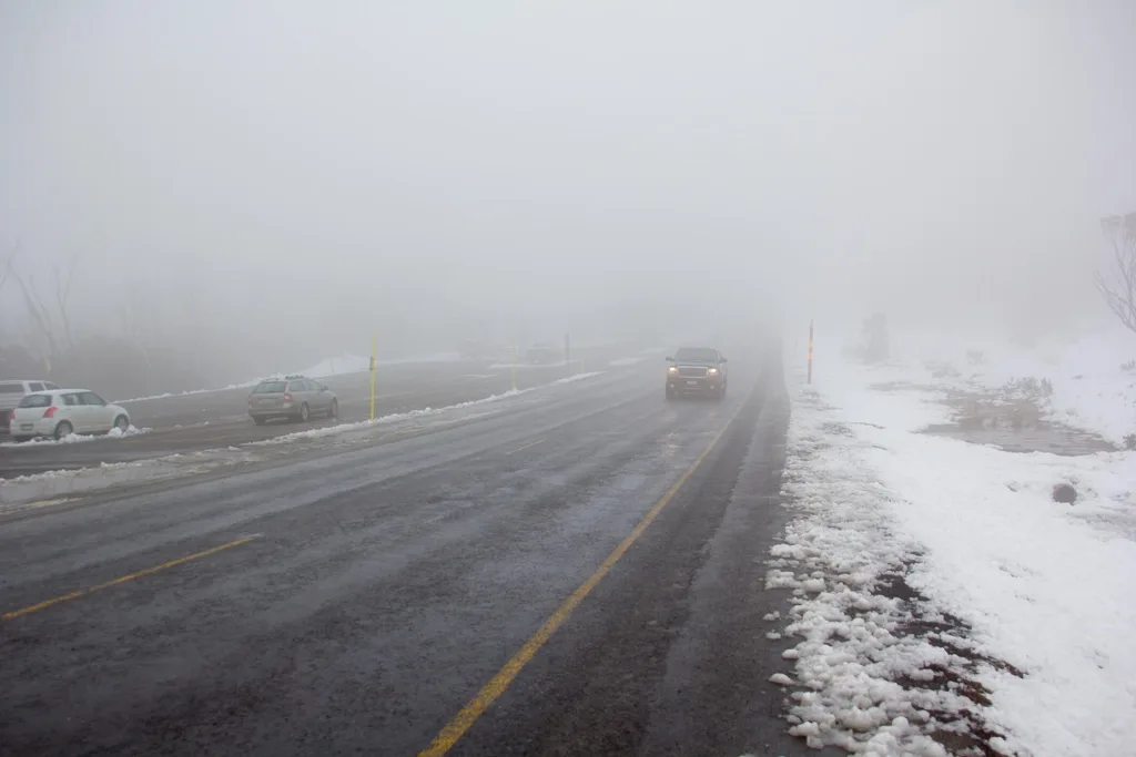 A foggy road in Australia with a car driving