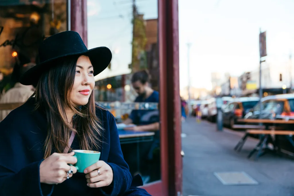 A lady drinking coffee at a cafe in Fitzroy, Melbourne