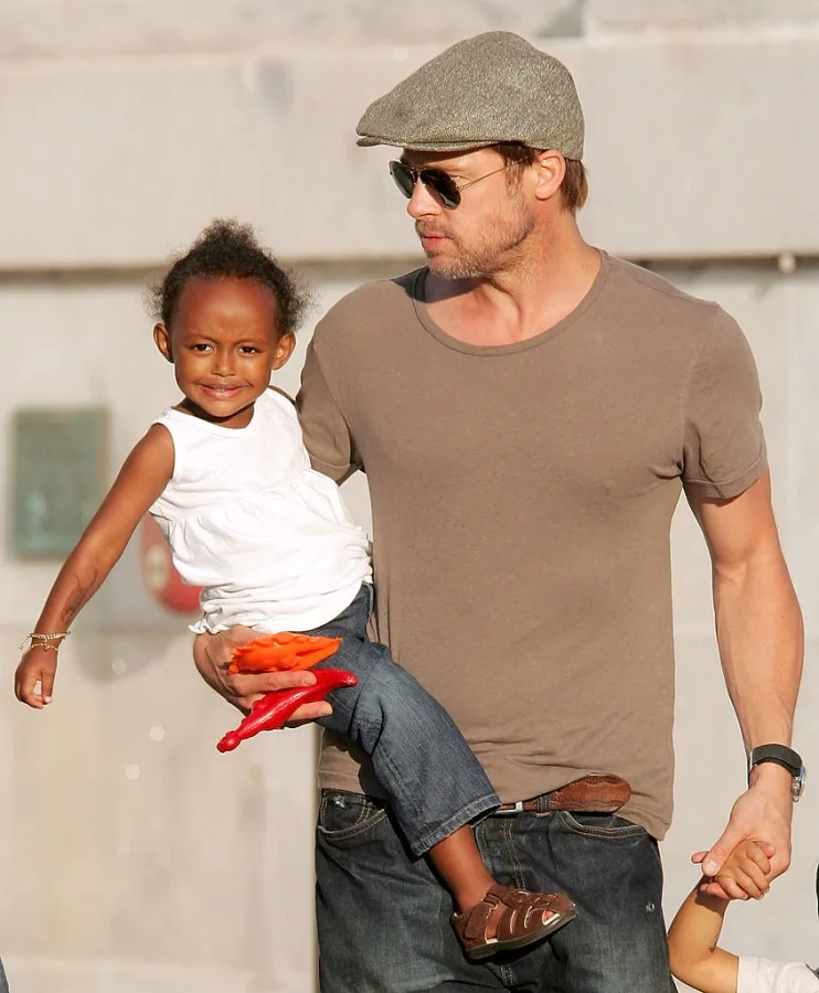 Brand Pitt holding Zahara Marley Jolie-Pitt in his arms